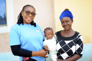 Grace posing with a client and her baby